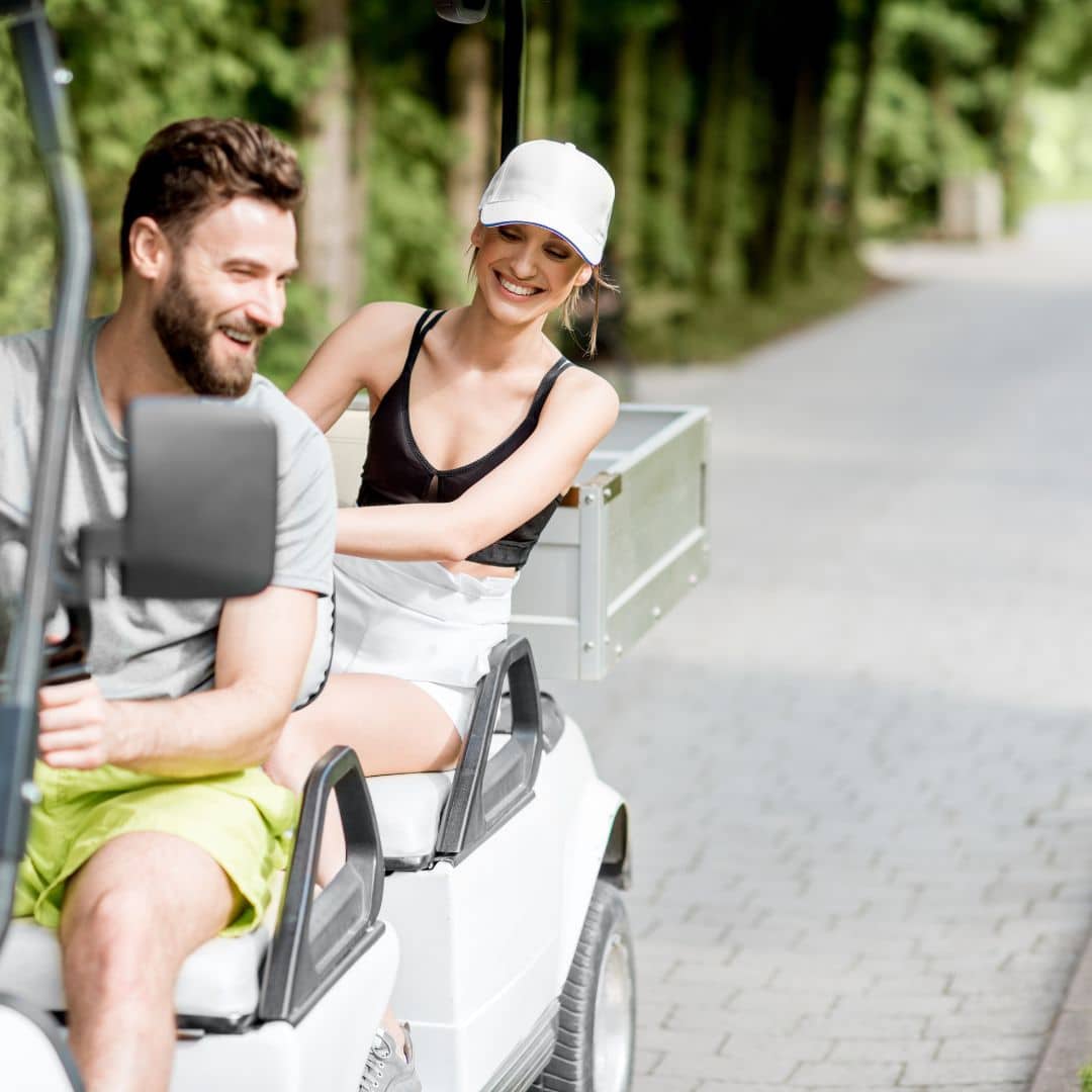 man and woman riding in golf cart