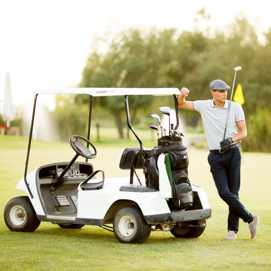 golfer leaning on golf cart